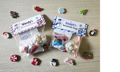 two bags filled with candy sitting on top of a wooden table next to other candies