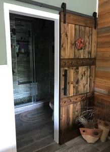 an open door leading to a bathroom with wooden walls