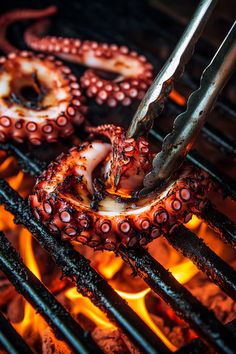 octopus rings being cooked on the grill with tongs