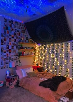 a bedroom with lights on the walls and a bed covered in blankets, pillows and blankets