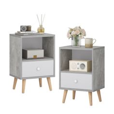 two white and grey nightstands with flowers on each side, one has an alarm clock