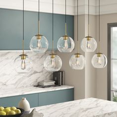 a kitchen with marble counter tops and hanging lights