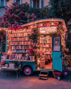 an old truck is decorated with flowers and bookshelves for the book store's display