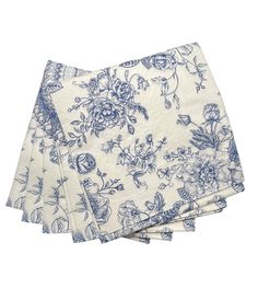 three napkins with blue and white floral designs on the front, one is folded in half