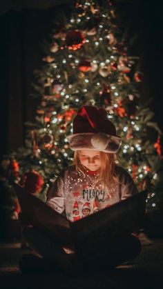 Christmas Book Picture With Light, Kids In Front Of Christmas Tree Pictures, Kids Christmas Tree Pictures, Camera Settings For Christmas Tree Photo, Family Diy Christmas Photos, Child Christmas Photoshoot, Night Time Christmas Photoshoot, Christmas Light Pictures Kids, Christmas Light Family Photos