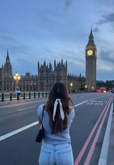 a woman standing in front of the big ben clock tower