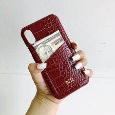 a woman holding up her phone case with money in it