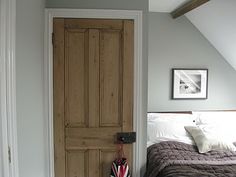 a bed sitting in a bedroom next to a wooden door with an american flag on it