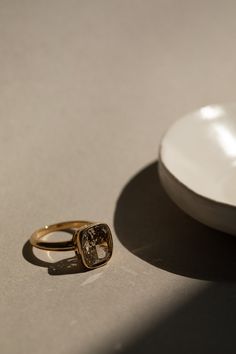 a white plate and a gold ring on a table