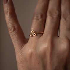 a person's hand with a gold ring on it and a diamond in the middle