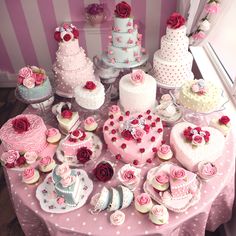 a table topped with lots of cakes and cupcakes