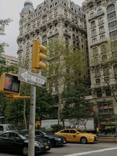 a traffic light sitting on the side of a road next to tall buildings