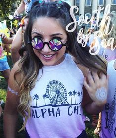 a girl with her face painted in the shape of a ferris wheel at an event