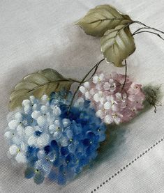 some flowers are sitting on a white tablecloth with blue and pink flowers in the center