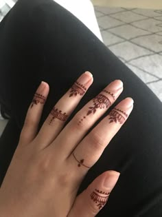 a woman's hand with henna tattoos on it