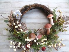 a wreath with mushrooms, berries and pine cones