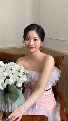 a woman sitting on a chair holding a bouquet of flowers