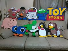 a group of stuffed animals sitting on top of a couch in front of a toy story sign