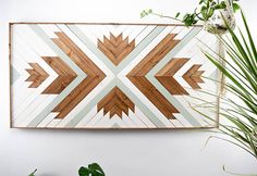 a wall hanging made out of wood with an arrow design on the top and bottom