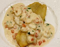 a white plate topped with ravioli and shrimp