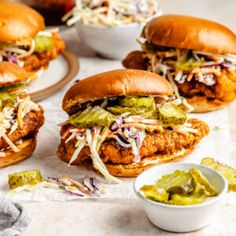 chicken sandwiches with coleslaw slaw and pickles on the side, ready to be eaten