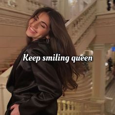 a woman standing next to a stair case with the words keep smiling queen on it