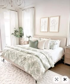 a bedroom with white and green bedding, chandelier, rugs and pictures on the wall