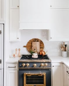 a stove top oven sitting inside of a kitchen next to white cabinets and counter tops