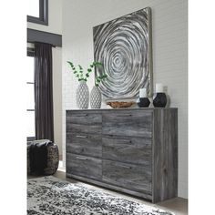 a large wooden dresser sitting next to a white and black rug on top of a hard wood floor