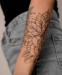 a woman's arm with a tattoo on it that has leaves and flowers on it