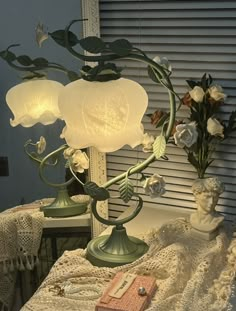 a lamp that is sitting on a table next to a vase with flowers in it