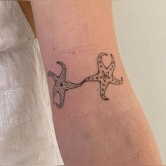 a small starfish tattoo on the arm