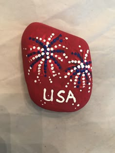 a red rock with fireworks painted on it