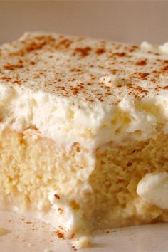 a piece of cake with white frosting and cinnamon sprinkles on top