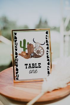 a table with a sign that says table one and some cowboy boots on the table