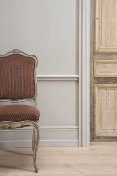 an old chair sitting in front of a wooden door