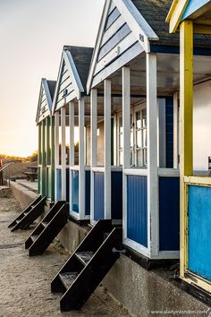 the beach huts are lined up on the sand