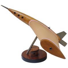 a wooden model of a rocket ship on a stand