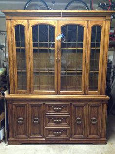 a large wooden china cabinet with glass doors