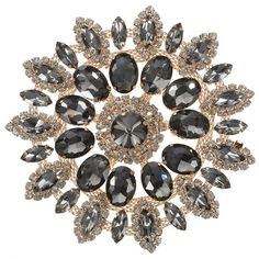 a brooch with lots of black and white stones on it's center piece