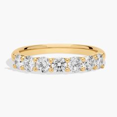 a yellow gold ring with five stones on the side and two rows of diamonds in each band