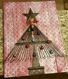 a christmas tree made out of forks on top of a wooden board with ornaments around it