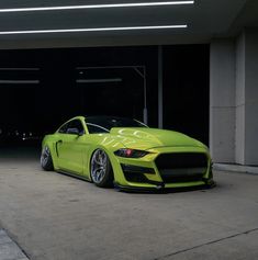 a lime green car parked in front of a building