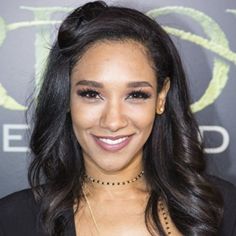 a woman with long dark hair smiling at the camera