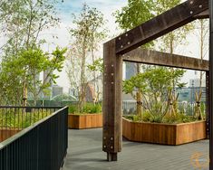 an outdoor deck with wooden planters and trees