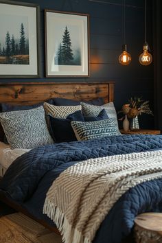 a bed with blue and white comforter next to two framed pictures on the wall