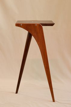 a small wooden table with one leg bent down and the other end turned upside down