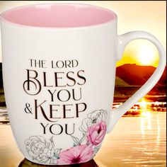 a pink and white coffee mug with the words, the lord bless you & keep you