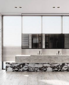 a bathroom with marble counter tops and two sinks in front of large windows that have blind shades on them