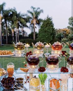 an assortment of teas and desserts on a glass table